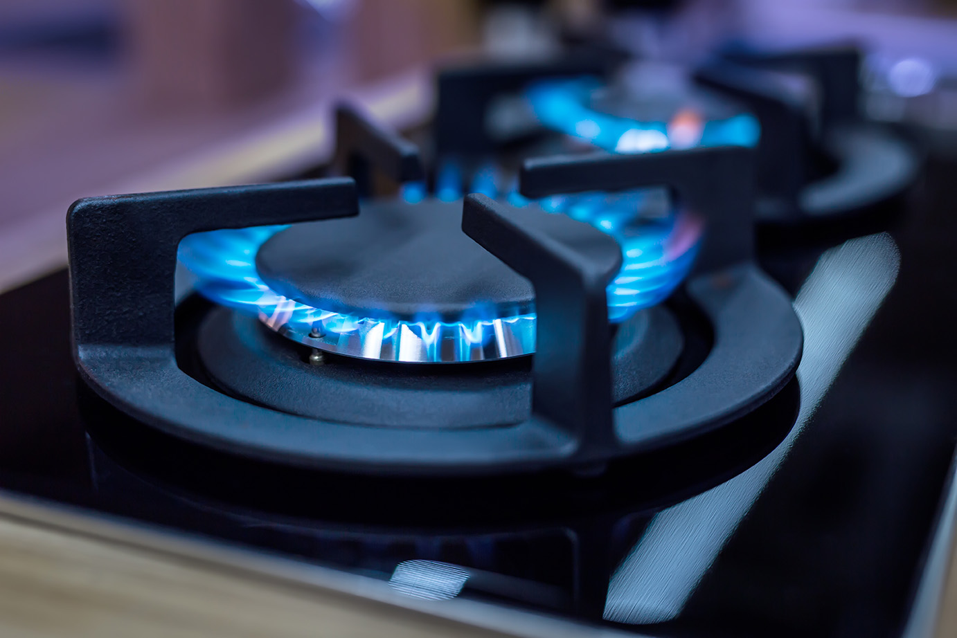 Modern kitchen stove cook with blue flames burning.