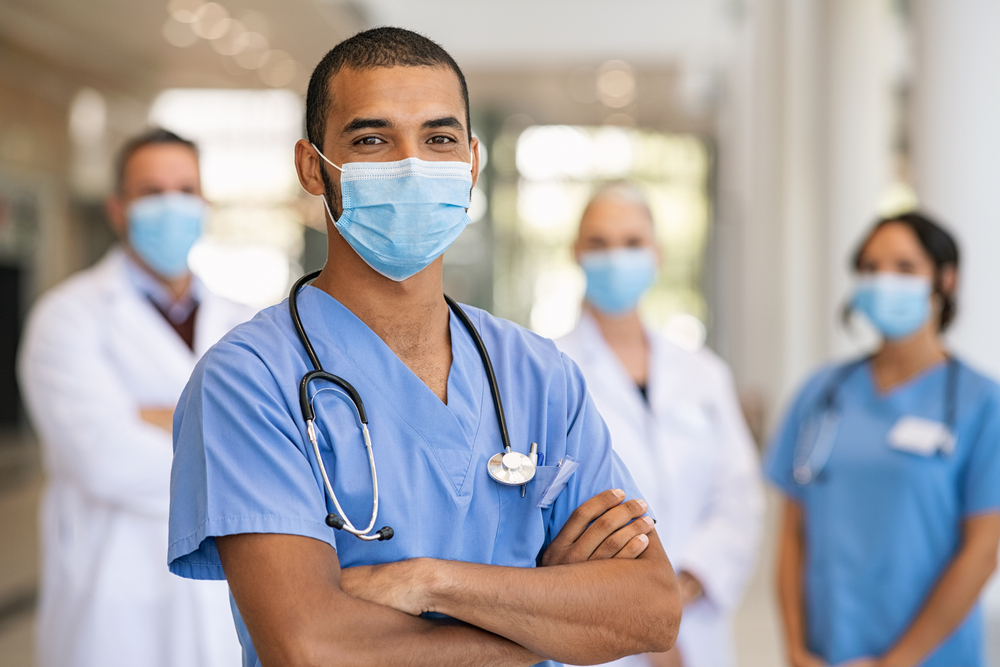 Confident,Multiethnic,Male,Nurse,In,Front,Of,His,Medical,Team