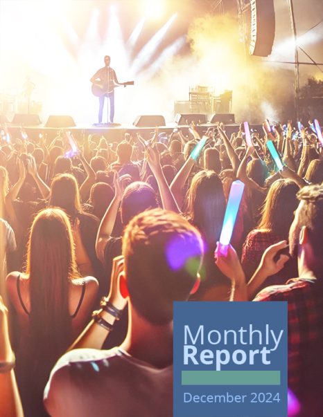 December monthly report cover. Image of a concert seen from the audience's perspective.