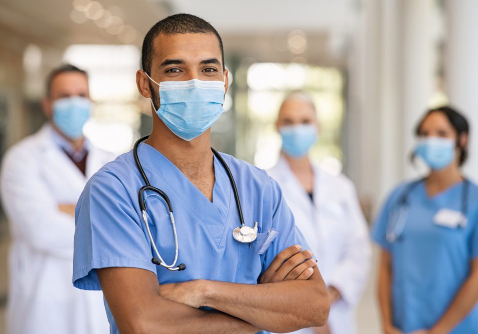 Confident,Multiethnic,Male,Nurse,In,Front,Of,His,Medical,Team