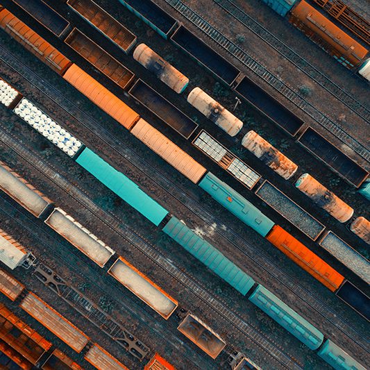 Aerial view of colorful freight trains on the railway station. Cargo trains close-up. Wagons with goods on railroad. Heavy industry. Industrial conceptual scene with trains. Top view. Vintage style