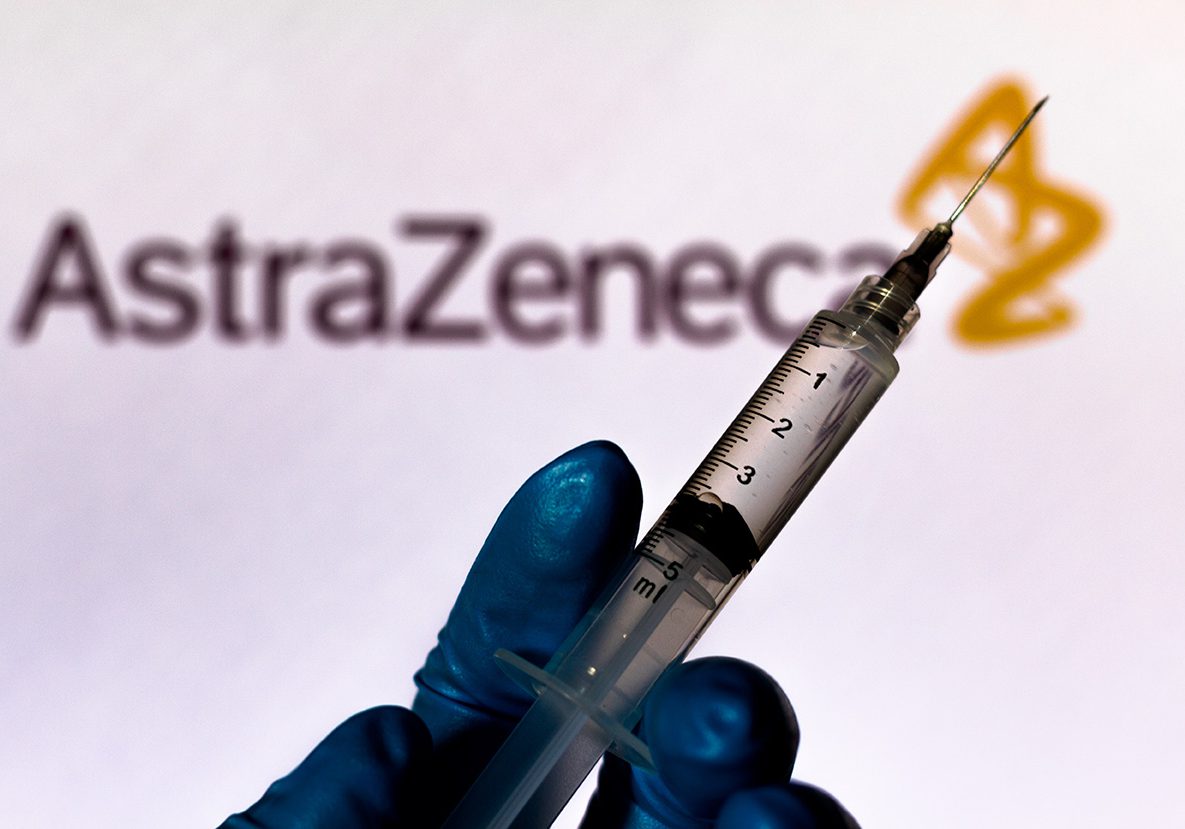 October 6, 2020, Brazil. In this photo illustration the medical syringe is seen with AstraZeneca company logo displayed on a screen in the background